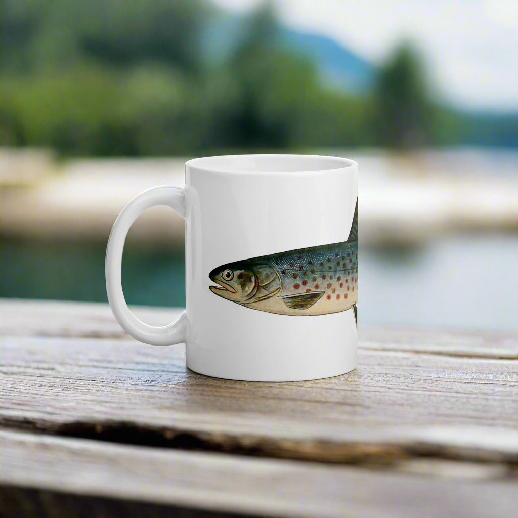 rangeley trout coffee mug on a table waterfront view